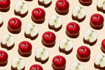 Red apples on a beige background, laid out in a row. View from above.