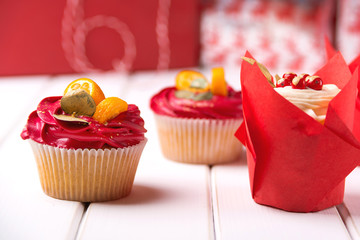 Tasty cupcakes for Valentine's day, birthday or Christmas party. Cupcakes decorated with kumquat and red berries, close up