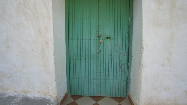 Old green wooden door of an old Moroccan mosque.