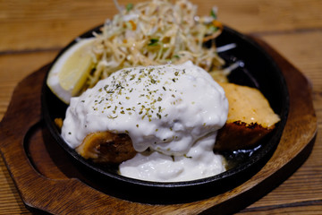 salmon grilled on hot plate with salad and lemon
