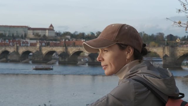 Girl on the embankment of old Europe. Cute girl tourist on the background of the old bridges of Prague.