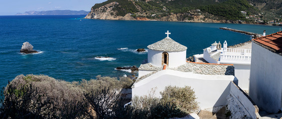 Fototapeta premium The panoramic view of the white, ancient church, the sea and the mountains