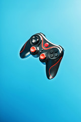 Game controller gamepad on blue background flying. Device to control and control the game.