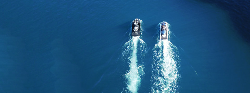 Aerial drone ultra wide photo of jet skis cruising in deep blue sea