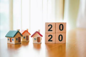 Wooden block year 2020 with mini house using as family and property real estate concept