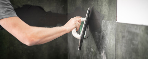 Fliesenleger bei der Arbeit, Renovierung eines Badezimmers