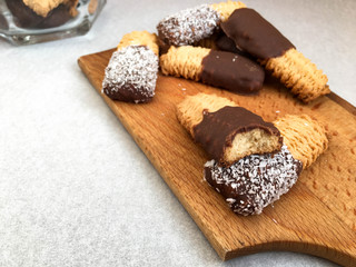 Homemade tea biscuits with chocolate and coconut on wooden board. Sweet pastry food photograph.
