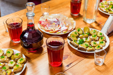Slices of rye bread spread with lard and pickles and red drink