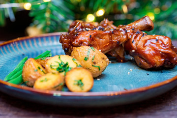 Roasted chicken quarter legs with baked potato on rustic background