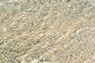 In the summer, the sun shines and the background of water waves flickers. The texture of the water.