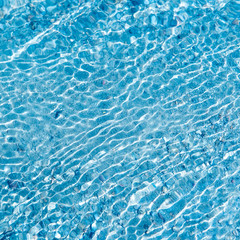 In the summer, the sun shines and the background of water waves flickers. The texture of the water.