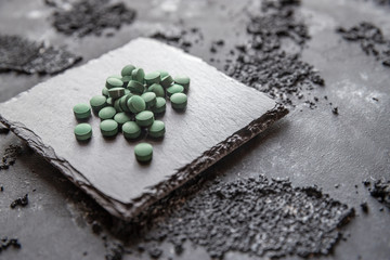 grüne Spirulina als Nahrungsergänzungsmittel auf grauem Grund © Kerstin