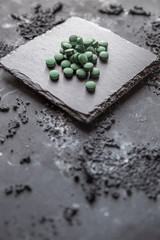 grüne Spirulina als Nahrungsergänzungsmittel auf grauem Grund