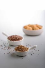 Obraz na płótnie Canvas flax seeds and flax seeds powder in small cups