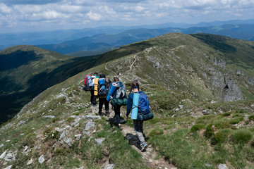 Fototapeta na wymiar A group of tourists walks along the trail on top of the hill