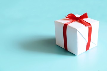 gift box with red ribbon and bow isolated on blue background.