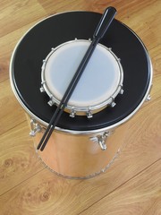 Two Brazilian percussion musical instruments: tamborim with drumstick and “tantan” (or “rebolo”) on a wooden surface. They are widely used in samba and pagode ensembles, popular Brazilian rhythms.