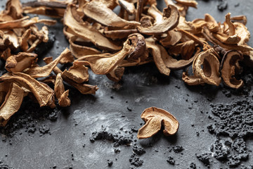 braune geschnittene gesammelte getrocknete Pilze auf grauem Grund im Herbst
