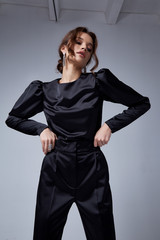 Sexy beautiful woman fashion glamour model brunette hair makeup wear black suit trousers jacket clothes office dress code casual party style accessory date walk girl skinny body shape studio.