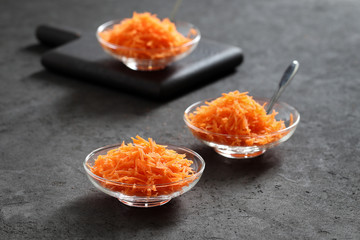 Still life with carrots on a dark background, vegetable salad with carrots, grated carrots