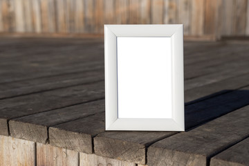 White photo frame on wooden background