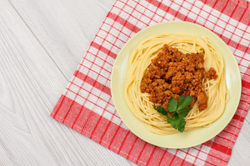 Spaghetti bolognese on a plate and napkin.