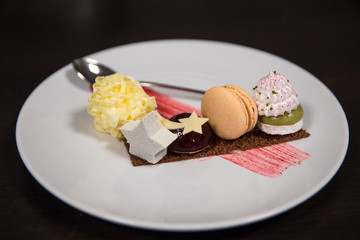 Different tasty desserts and confectionery on a white plate in a restaurant