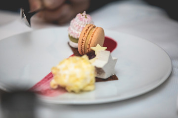 Different tasty desserts and confectionery on a white plate in a restaurant