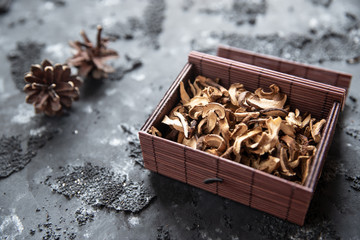 braune geschnittene gesammelte getrocknete Pilze auf grauem Grund im Herbst in einer Kiste
