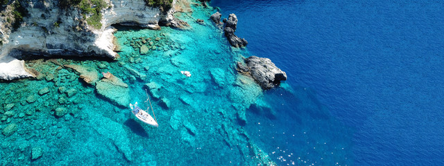Aerial drone ultra wide photo of breathtaking turquoise exotic bay of blue lagoon in island of Paxos visited by sail boats, Ionian, Greece - obrazy, fototapety, plakaty