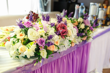 View of the served for decorated wedding dinner table in elite restaurant with beautiful flowers.