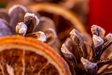 close up of a advent wreath with pine cones, dried orange slices and candles