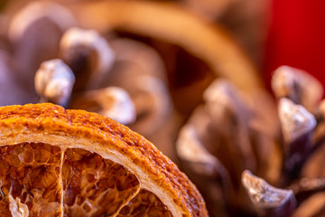 close up of a advent wreath with pine cones, dried orange slices and candles