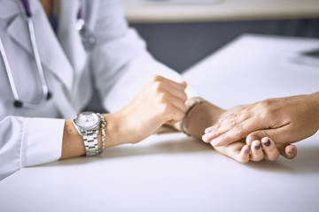 Obraz premium Woman doctor calms patient and holds hand