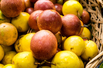 Closeup for passion fruits (Passiflora edulis) in basket made from bamboo. This fruit is immune booster, helps increase haemoglobin in our red blood cells and regulate the thyroid activity. 