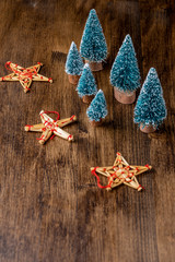 Top view Christmas decoration, with stars and trees, on dark wooden table in vertical