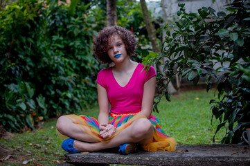 Naklejka premium Girl with blue lipstick sitting on the bench