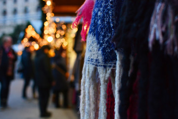 Fototapeta na wymiar Partially blurred photo of a traditional Christmas fair with scarves and lights
