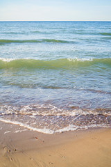 azure waves roll onto the sand of a beach on a sunny day, wallpapers for mobile devices