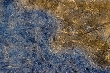 Blue and orange. Creative abstract frozen background of melting ice surface.