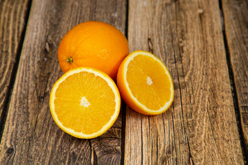 Oranges cut in half on a wooden background.