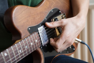 Naklejka premium Man Strums Chord On Guitar