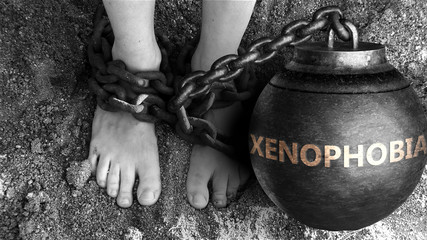 Xenophobia as a negative aspect of life - symbolized by word Xenophobia and and chains to show burden and bad influence of Xenophobia, 3d illustration - obrazy, fototapety, plakaty