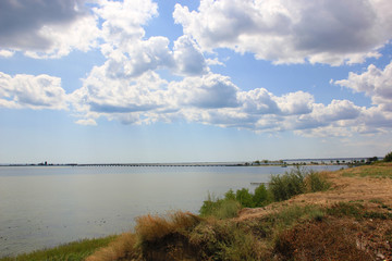 The nature landscape of sea, grass, sand, sky and clouds