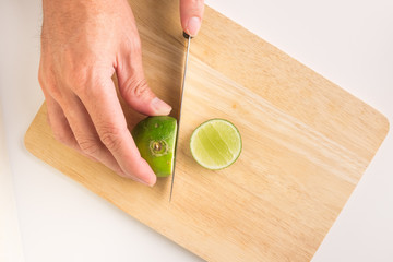 a man is holding fresh organic lemon with his hand on the wooden tray. lemon cuted for lemonade juice. lemon is citrus vegetable