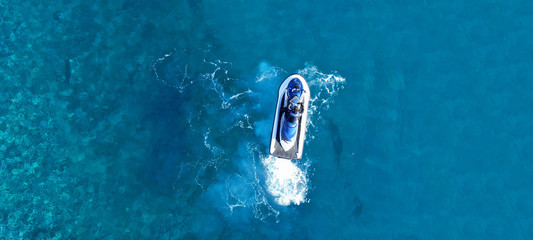 Fototapeta na wymiar Aerial drone ultra wide top view photo of jet ski water craft cruising in deep blue Mediterranean sea