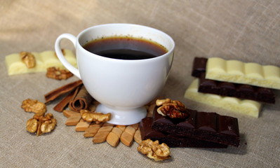A cup of coffee. White dishes. Coffee and chocolate. Morning ritual.