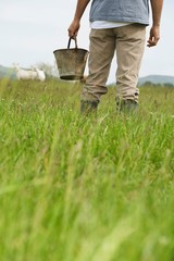 Midsection Of Man With Bucket In Field
