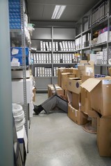 Lowsection Of Man With Laptop On Floor In Storage Room