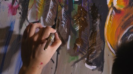 Artist designer draws an eagle on the wall. Craftsman decorator paints a picture with acrylic oil...